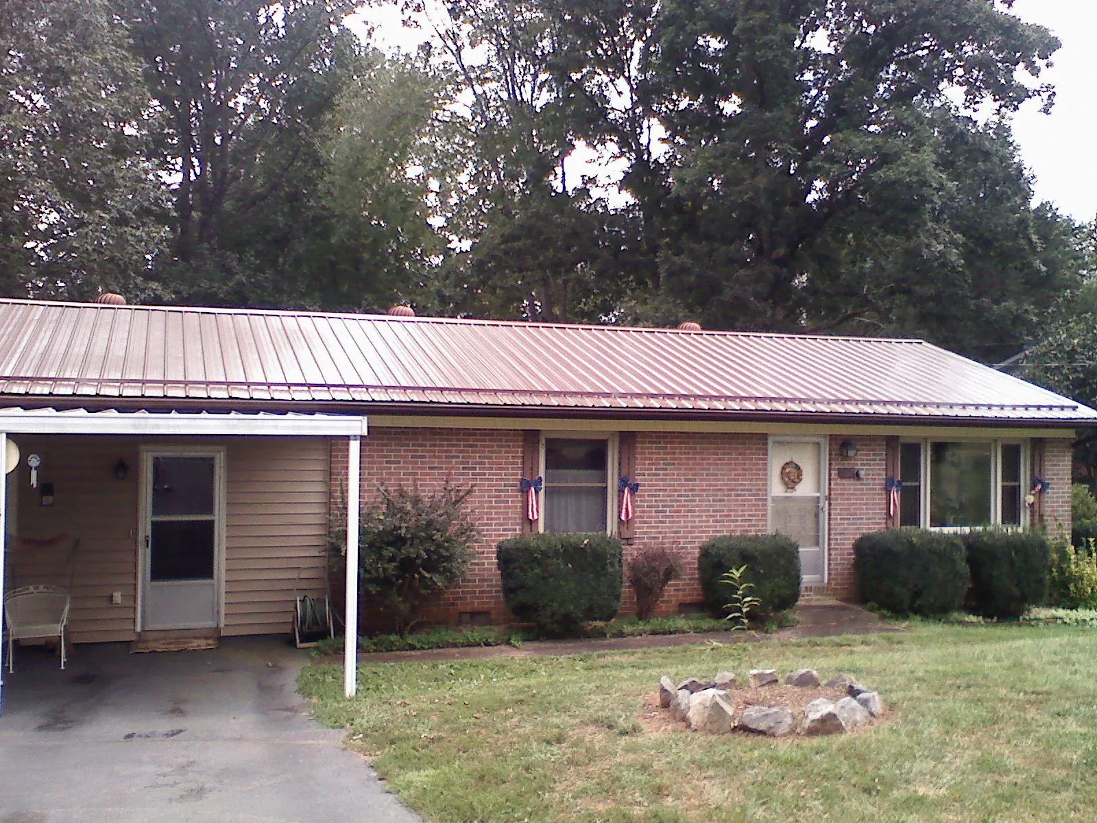 Bronze metal roof and carport on a brick ranch home — Roof Repair work by our crew in Italy