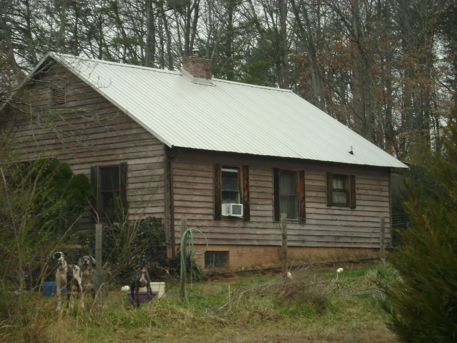 White metal roof on an old wood sided farmhouse, from a Metal Roof Installation job in Italy